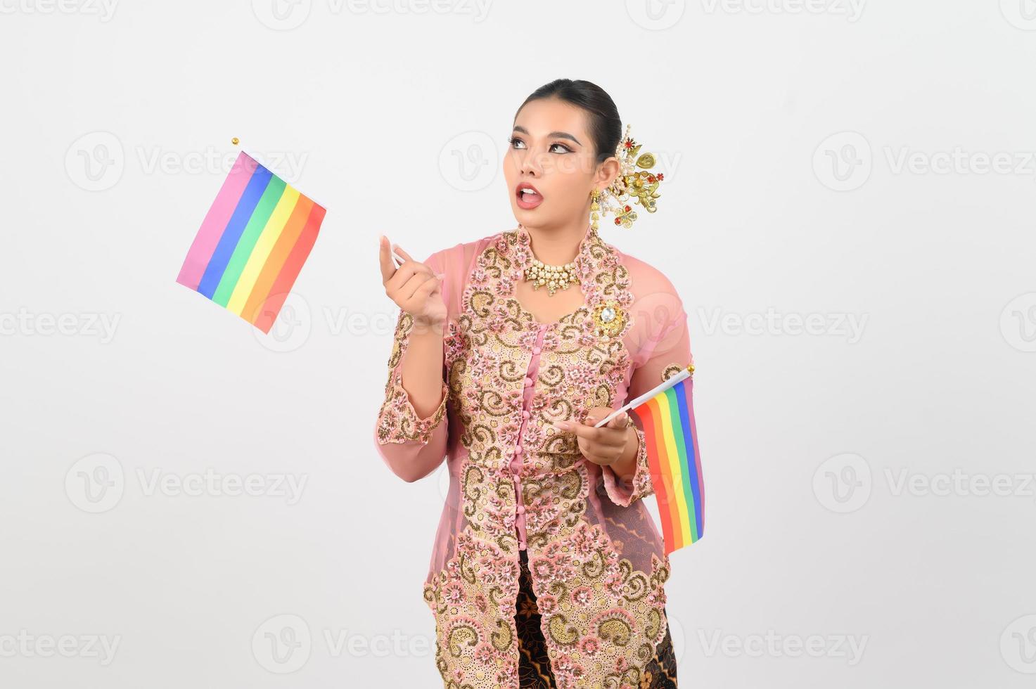 joven hermosa mujer vestida en la cultura local en la región sur con bandera arcoiris foto