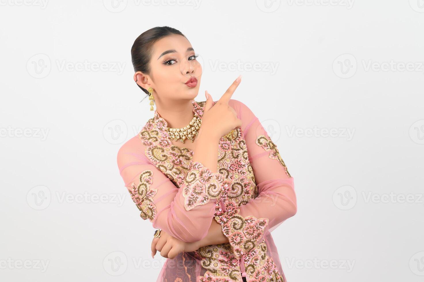 Young beautiful woman dress up in local culture in southern region point finger posture photo