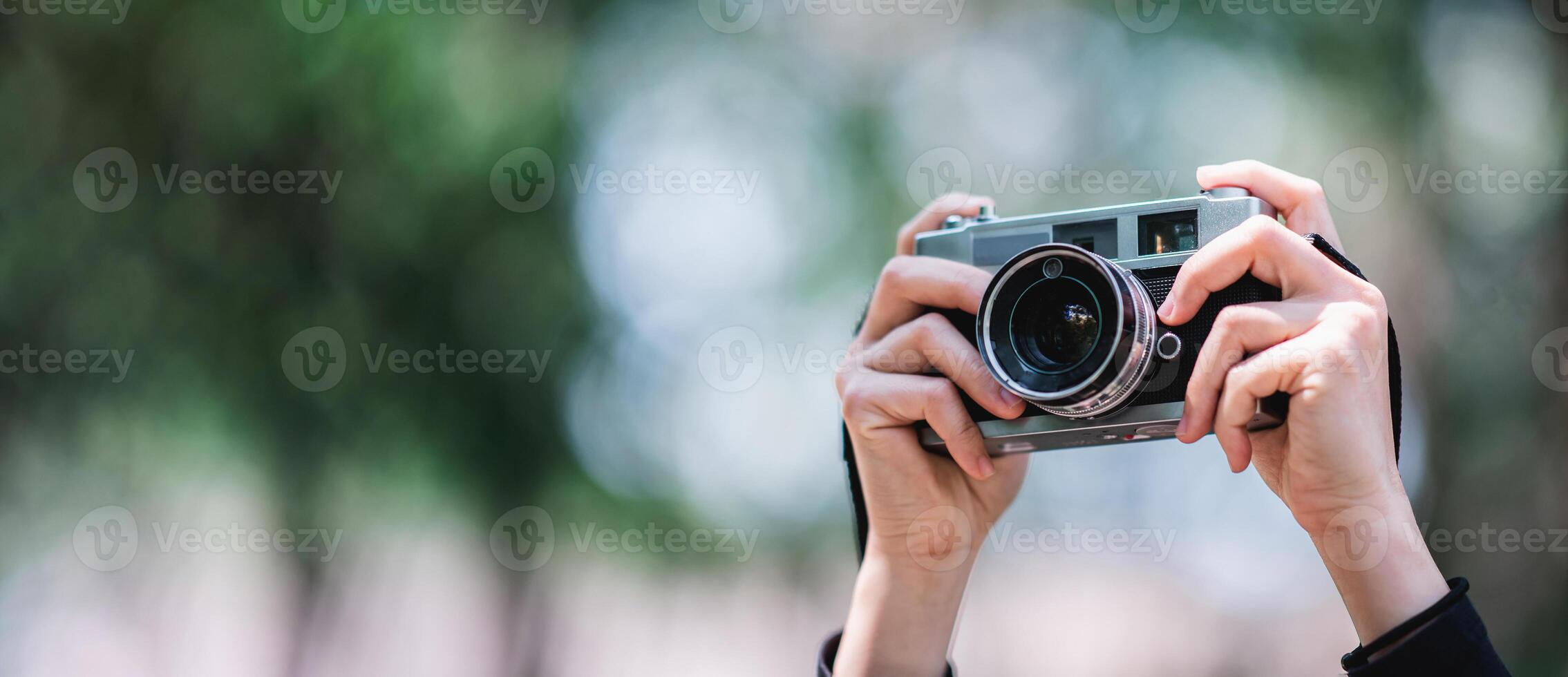 manos de hembra profesional fotógrafo toma instantáneas en bosque foto