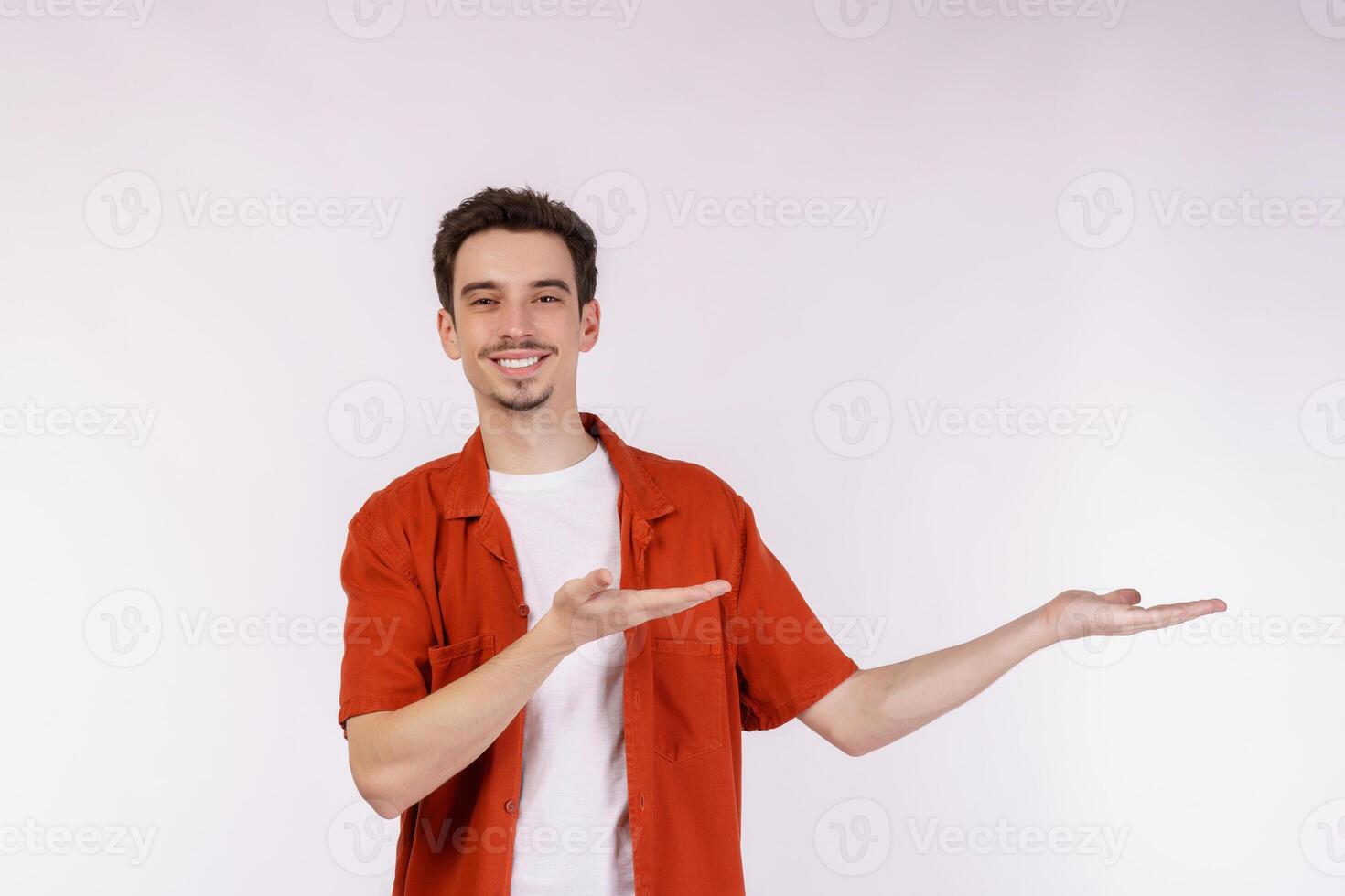 Portrait of happy smiling young man presenting and showing your text or product isolated on white background photo