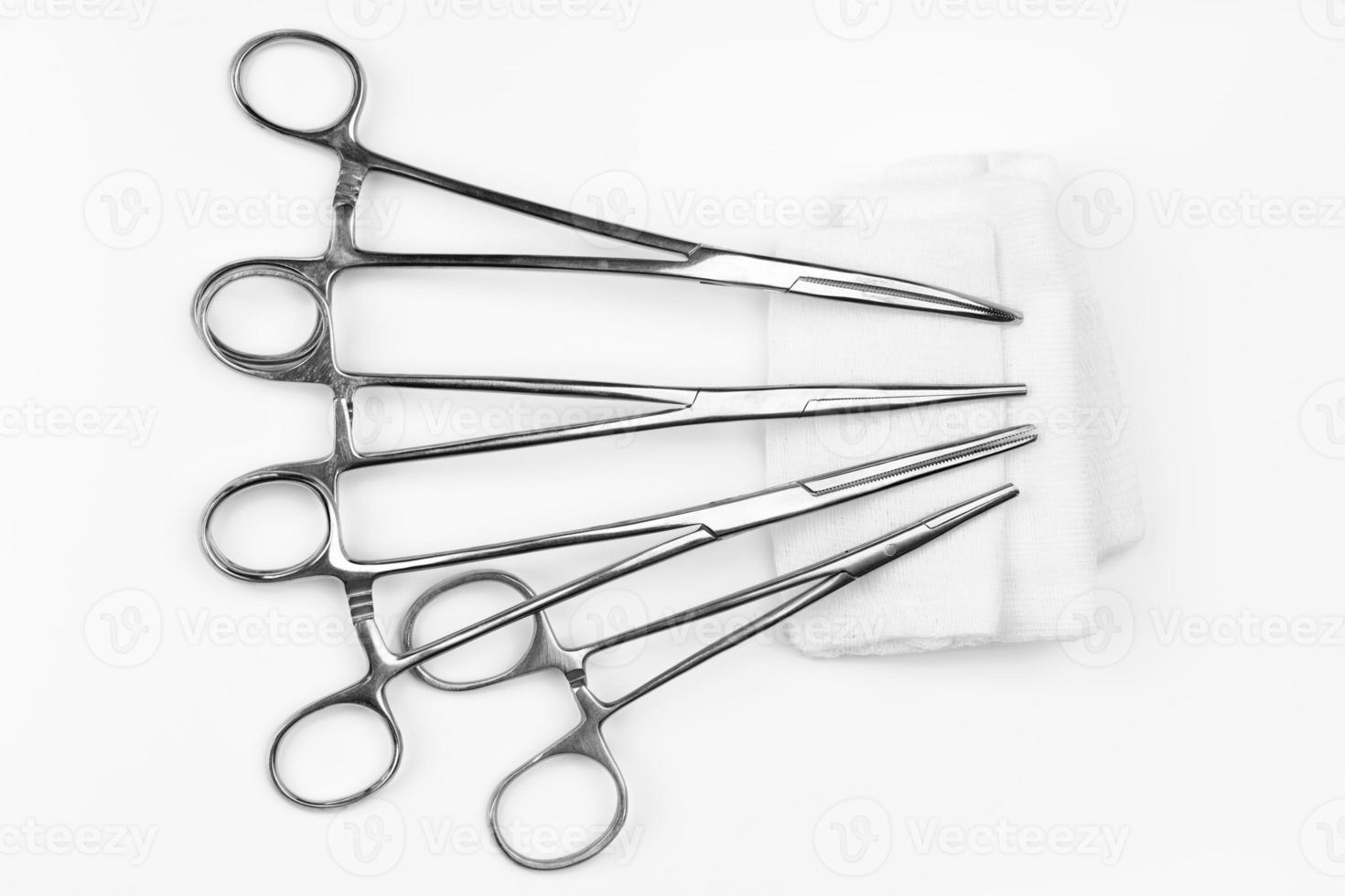 Surgical needle drivers lying on gauze swab. Medical instruments needle holders on white background photo