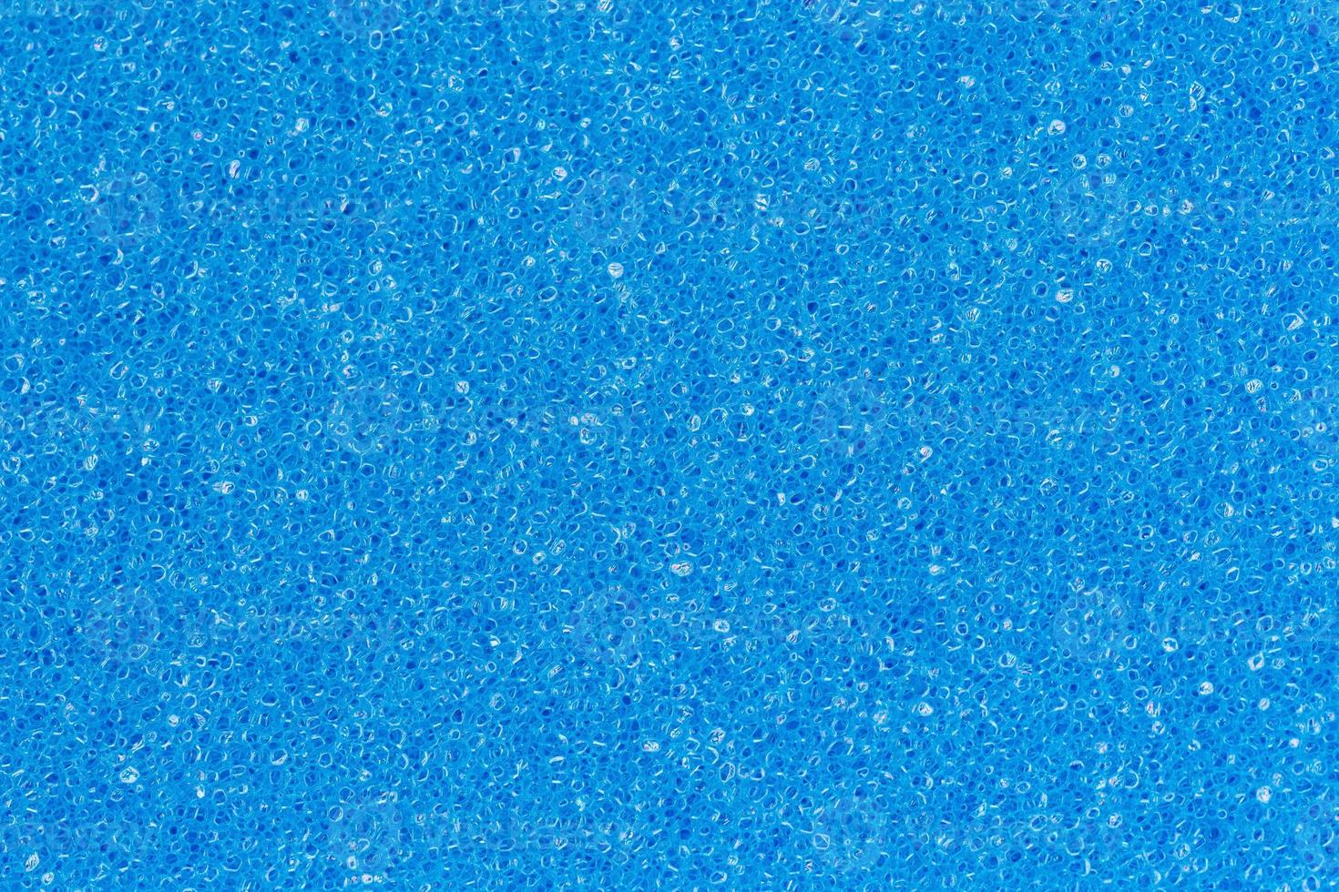 Foam sponge porous texture background deep sky blue color. Extreme close-up view of unique detail abstract synthetic material. Horizontal composition for design, colored decoration backdrop photo
