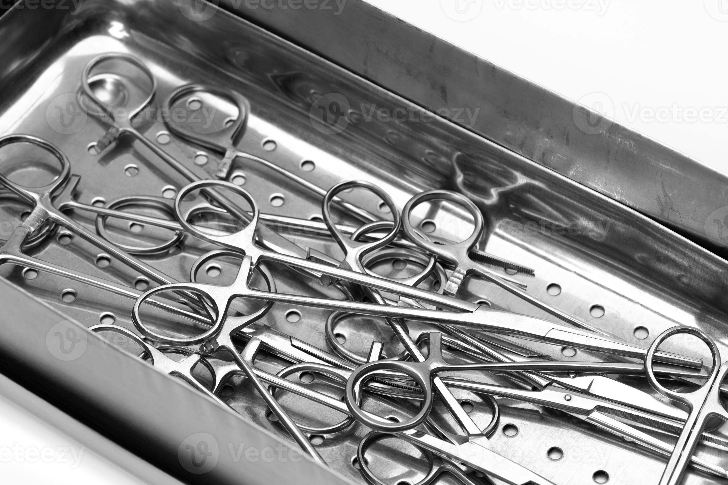 Lot of stainless surgical needle drivers lying on steel tray for