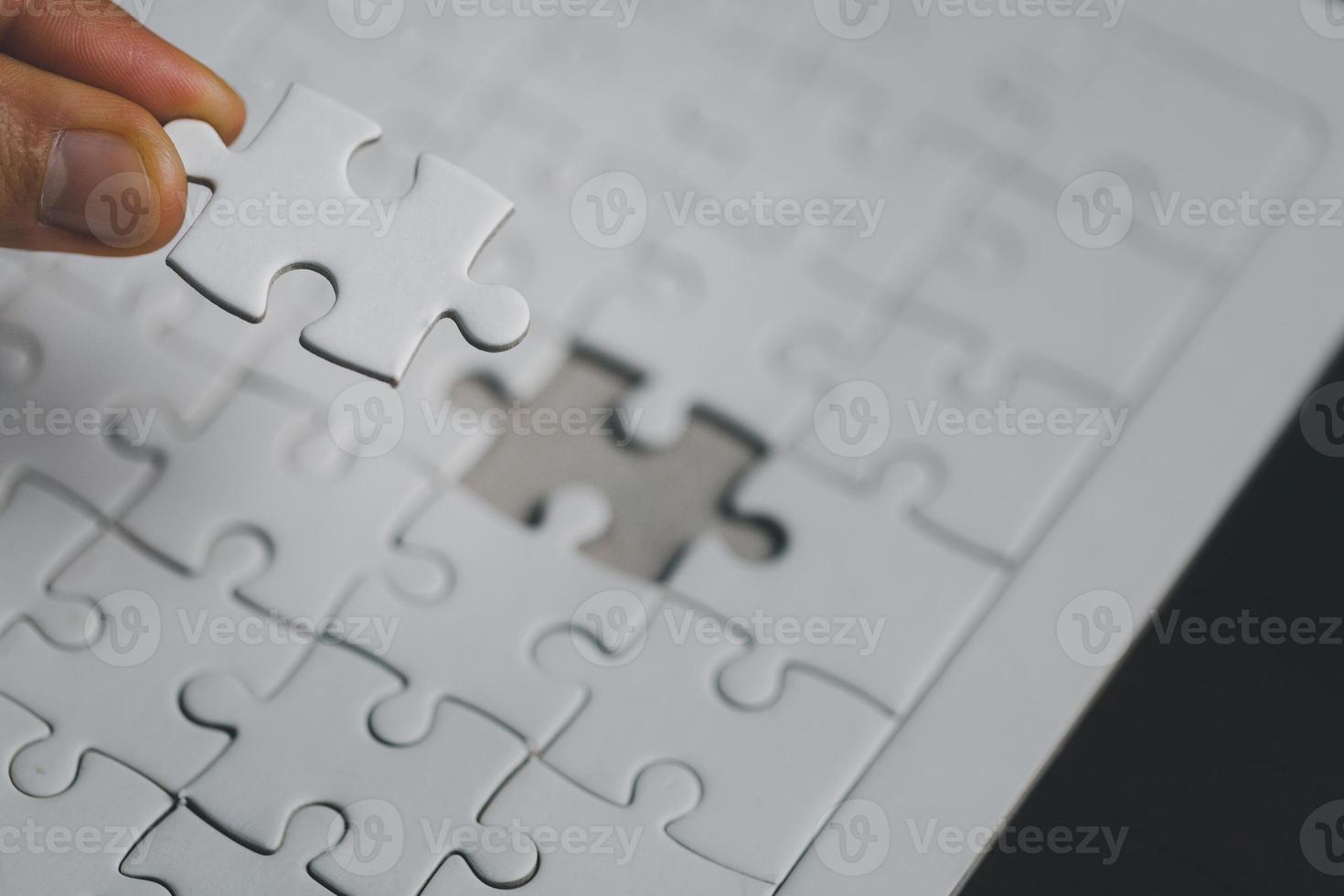 Business woman person hand holding puzzle piece idea for strategy and solution. Closeup part of one white jigsaw connect together. Concept of join cooperation success teamwork-problem corporate team photo