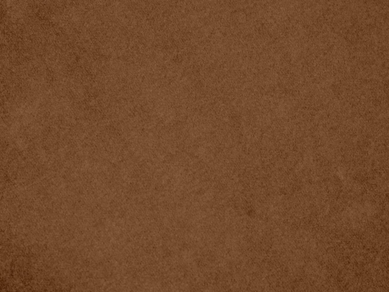 textura de tela de terciopelo de color marrón utilizada como fondo. fondo de tela marrón vacío de material textil suave y liso. hay espacio para el texto. foto