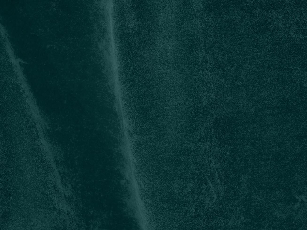 Dark green velvet fabric texture used as background. Empty green fabric