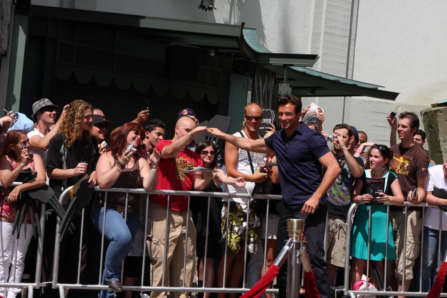 Hugh Jackman giving a fan the pen used to sign name at the Hugh Jackman Handprint  Footprint Ceremony at Graumans Chinese Theater Forecourt in Los Angeles  California on April 21 20092009 photo