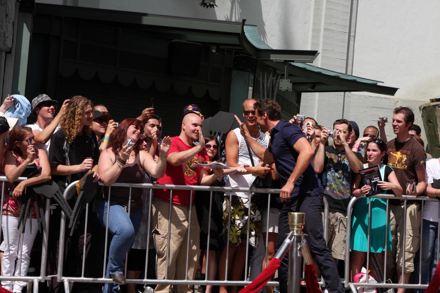 Hugh Jackman giving a fan the pen used to sign name at the Hugh Jackman Handprint  Footprint Ceremony at Graumans Chinese Theater Forecourt in Los Angeles  California on April 21 20092009 photo