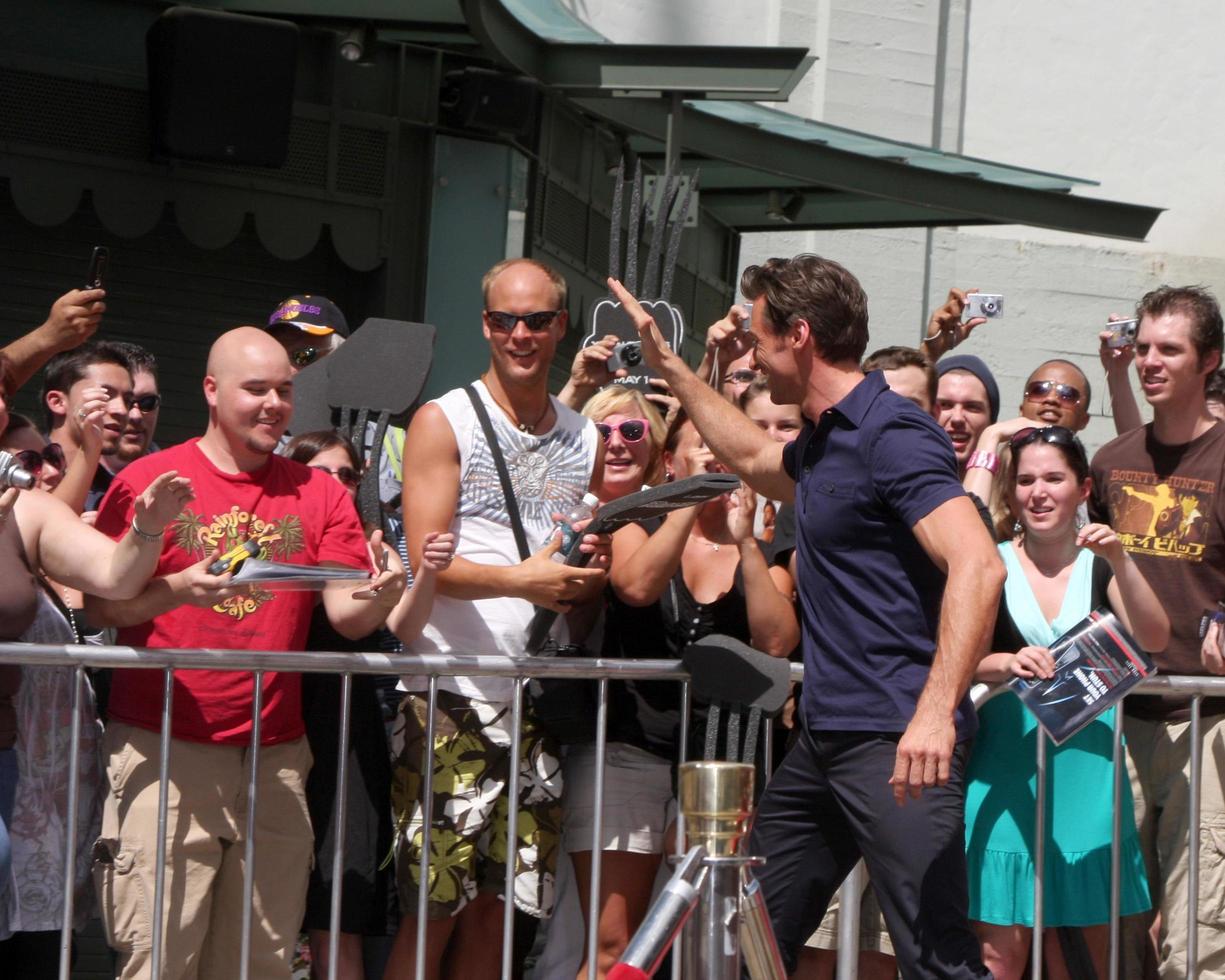 Hugh Jackman giving a fan the pen used to sign name at the Hugh Jackman Handprint  Footprint Ceremony at Graumans Chinese Theater Forecourt in Los Angeles  California on April 21 20092009 photo