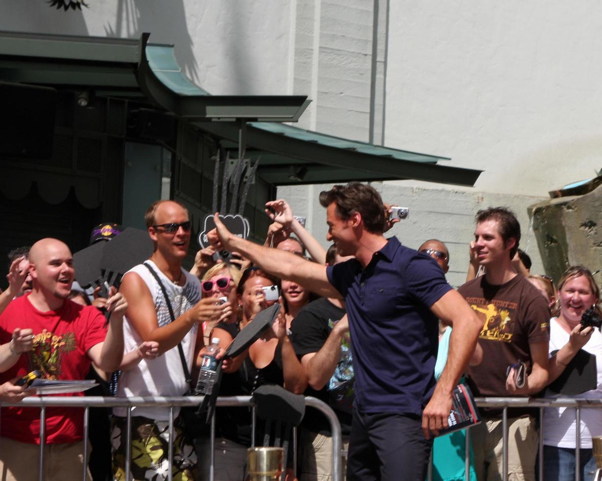Hugh Jackman giving a fan the pen used to sign name at the Hugh Jackman Handprint  Footprint Ceremony at Graumans Chinese Theater Forecourt in Los Angeles  California on April 21 20092009 photo