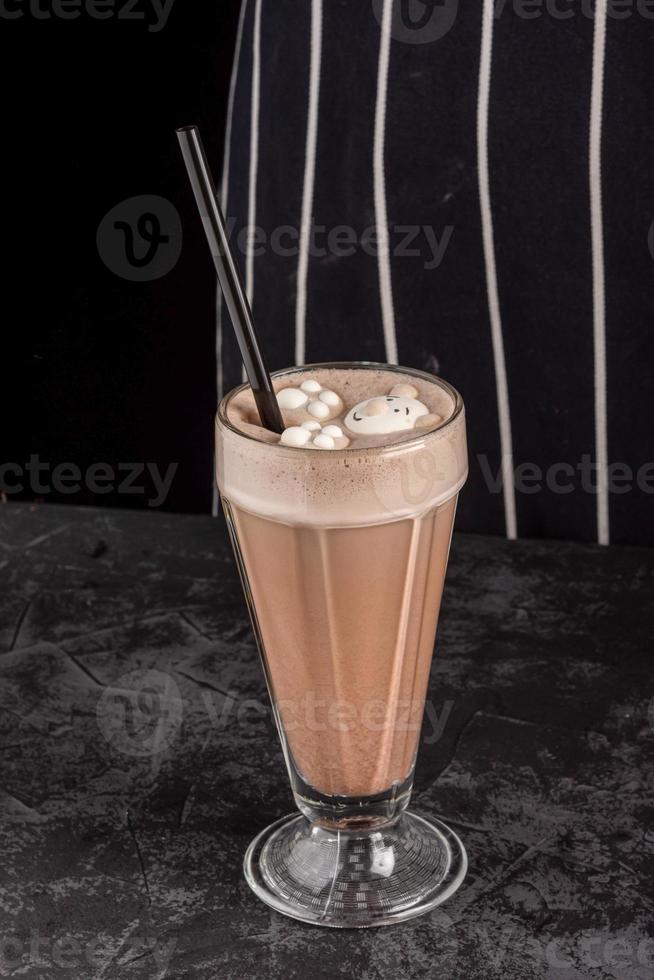 cocoa drink decorated with funny cookies on a dark background photo