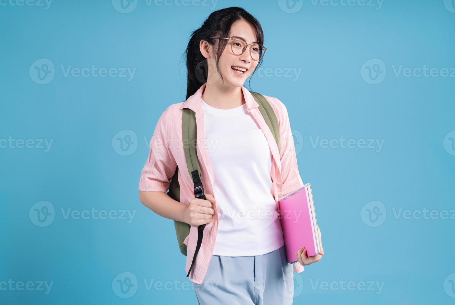 Young Asian student on blue background photo