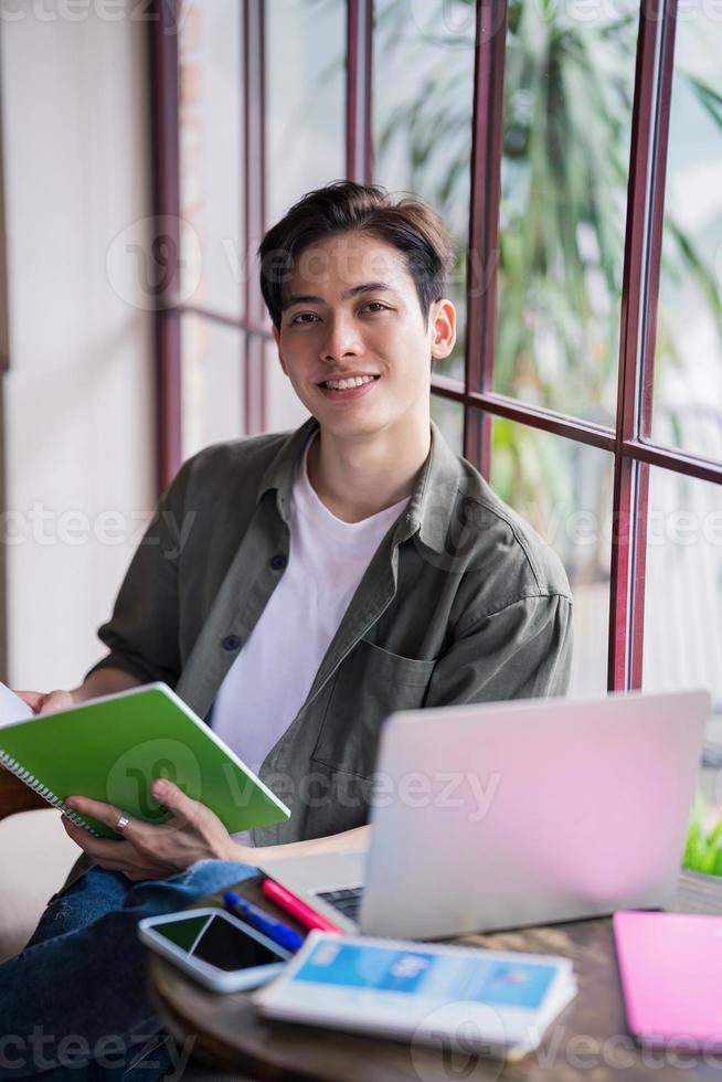Young Asian businessman working at coffee shop photo