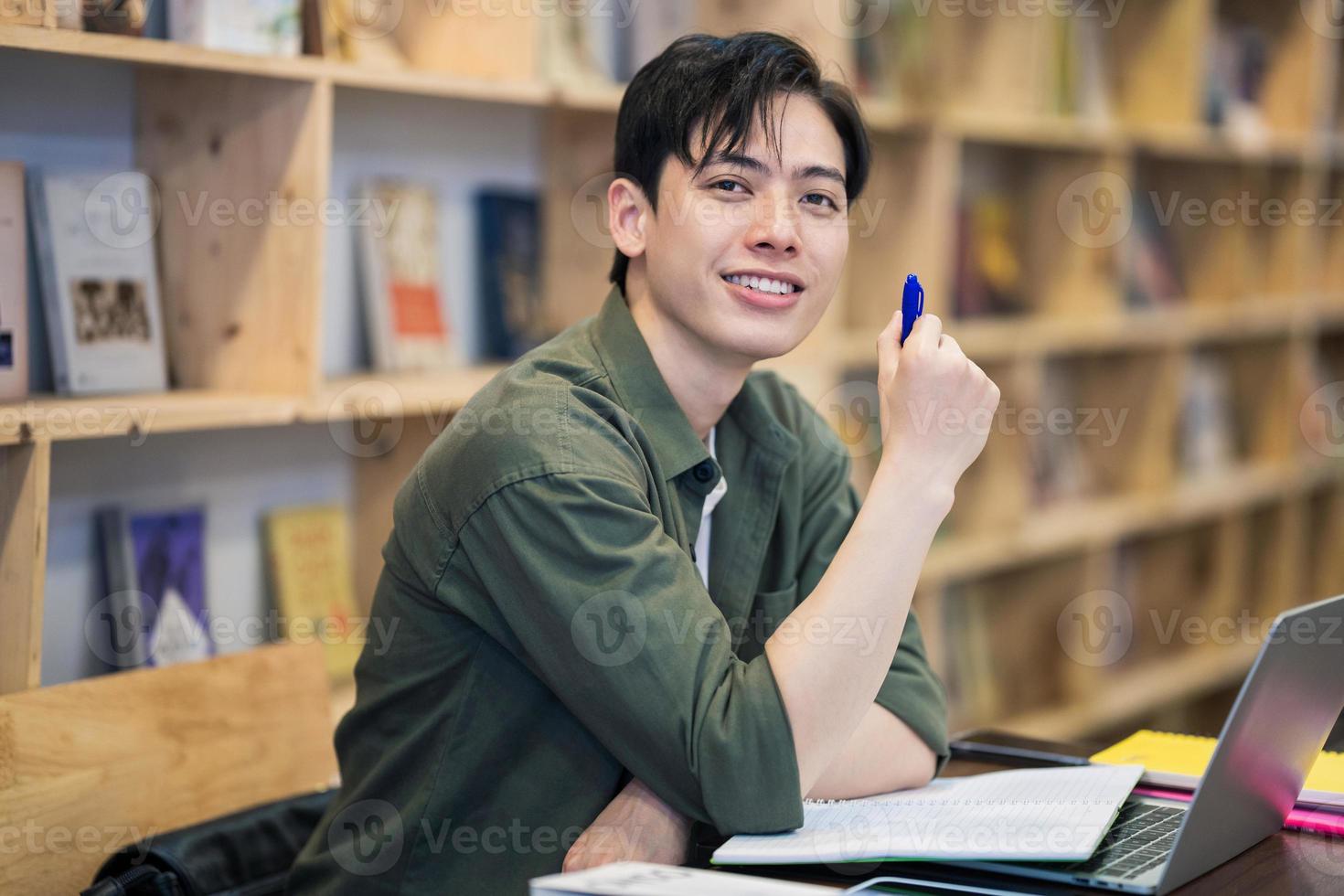 Young Asian man studying at library photo