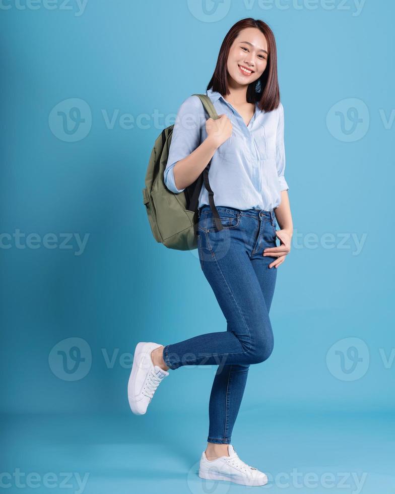 Young Asian student on blue background photo