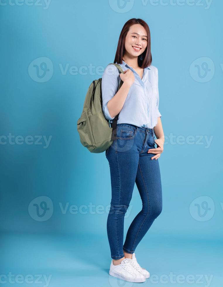 Young Asian student on blue background photo