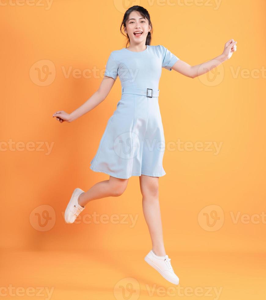 Young Asian woman wearing dress on background photo