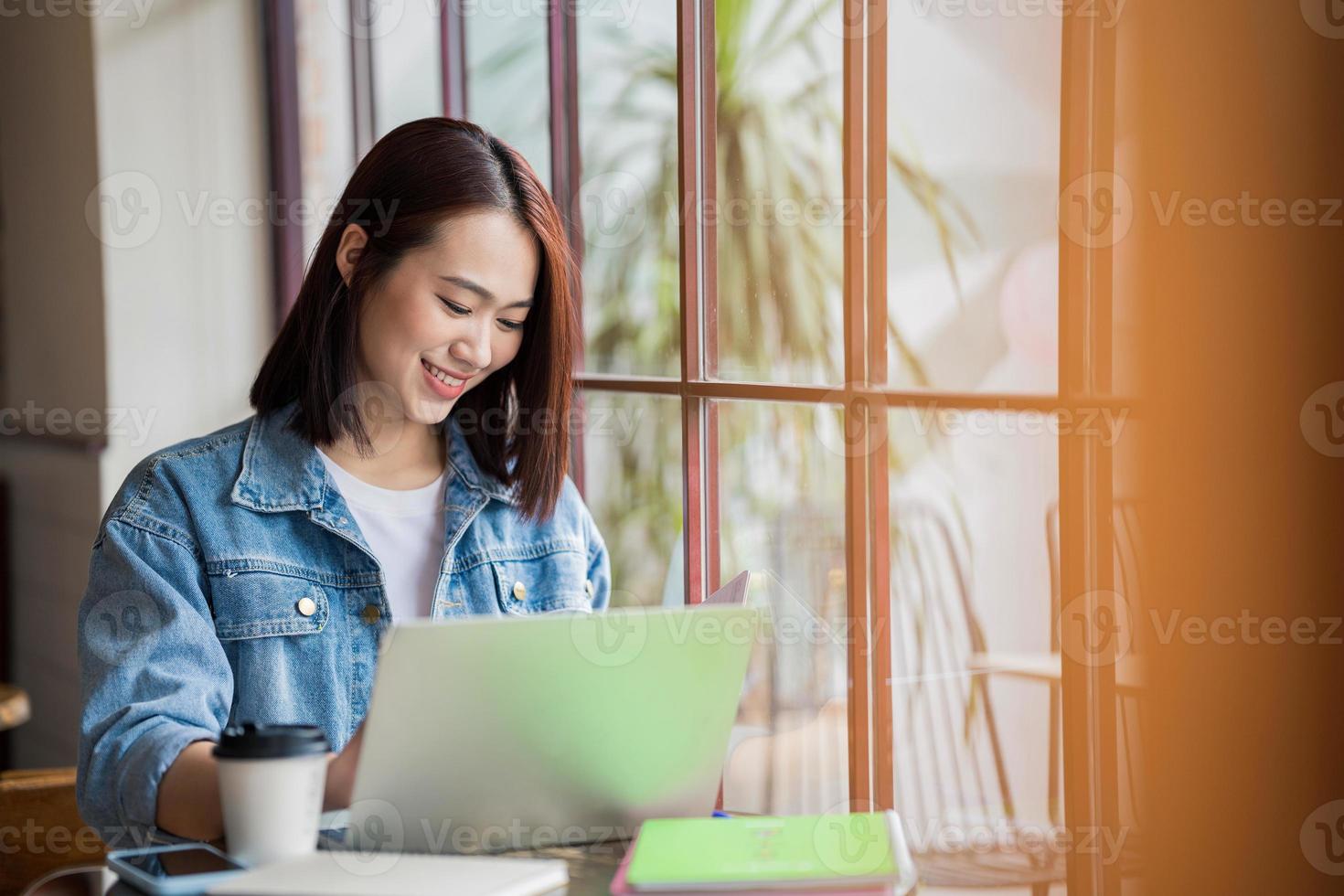 joven asiático mujer de negocios trabajando a café tienda foto