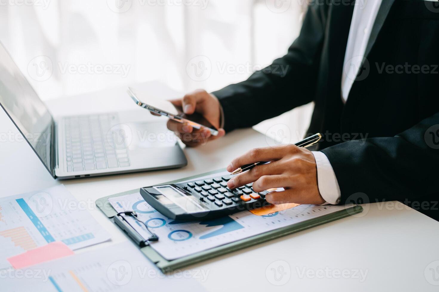 business documents on office table with smart phone and digital tablet and graph financial and woman working at office photo