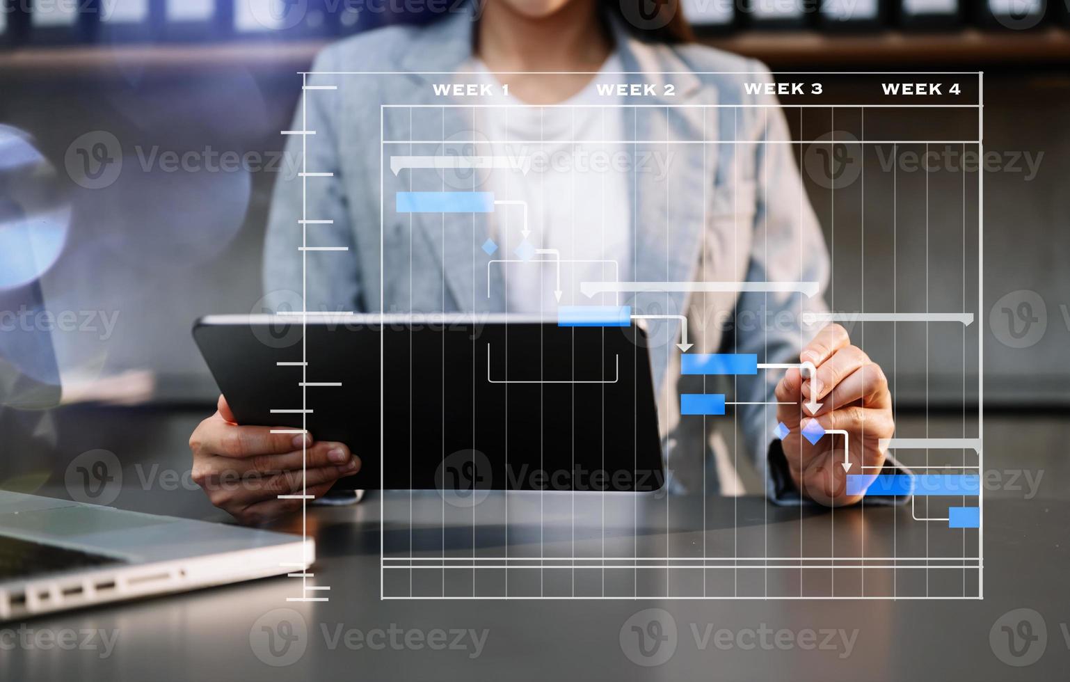 gerente de proyecto trabajando y actualizando tareas con hitos, planificación de progreso y diagrama de programación de diagrama de Gantt. Tranvía comercial trabajando en la oficina foto