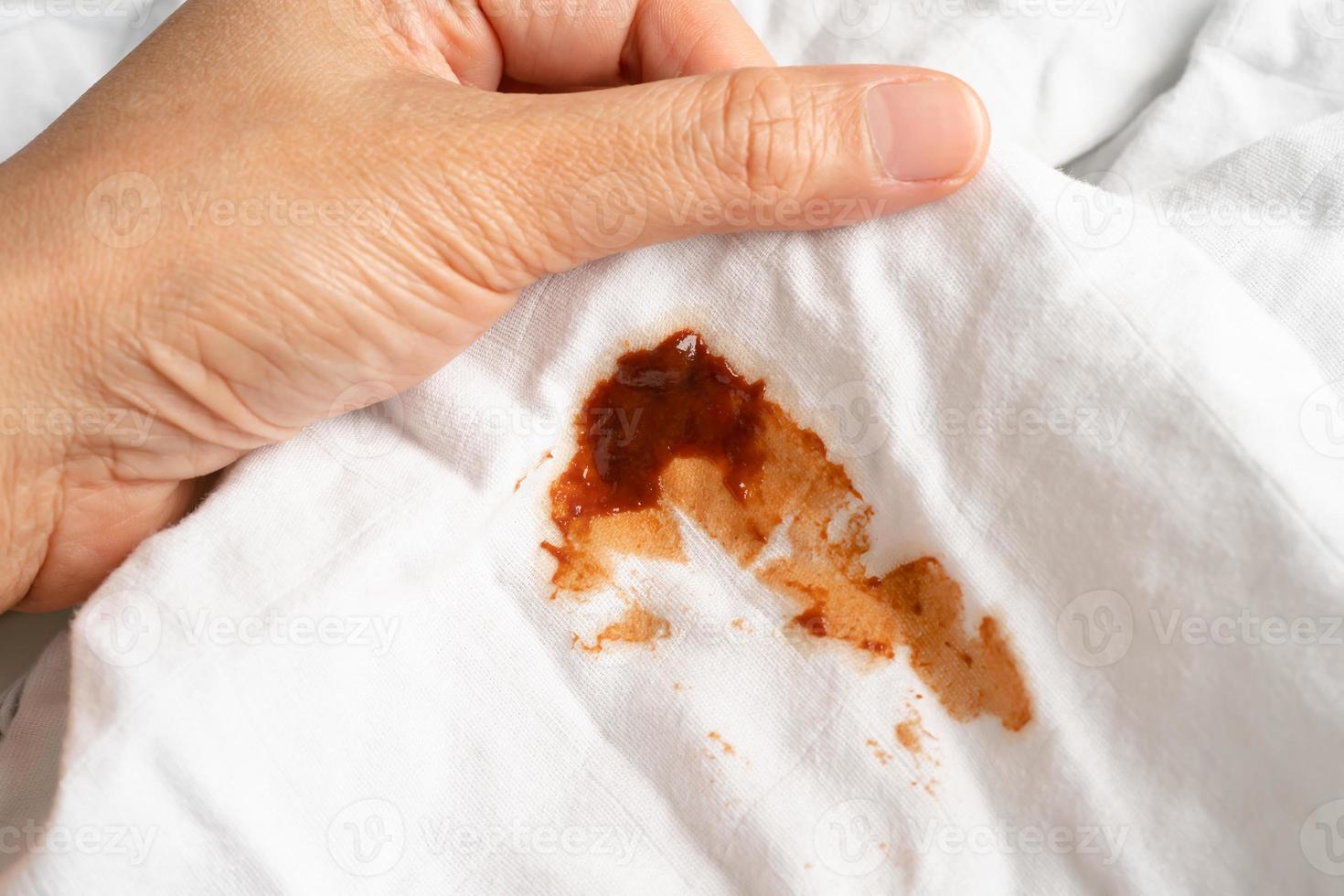 Dirty tomato sauce stain or ketchup on cloth to wash with washing powder, cleaning housework concept. photo