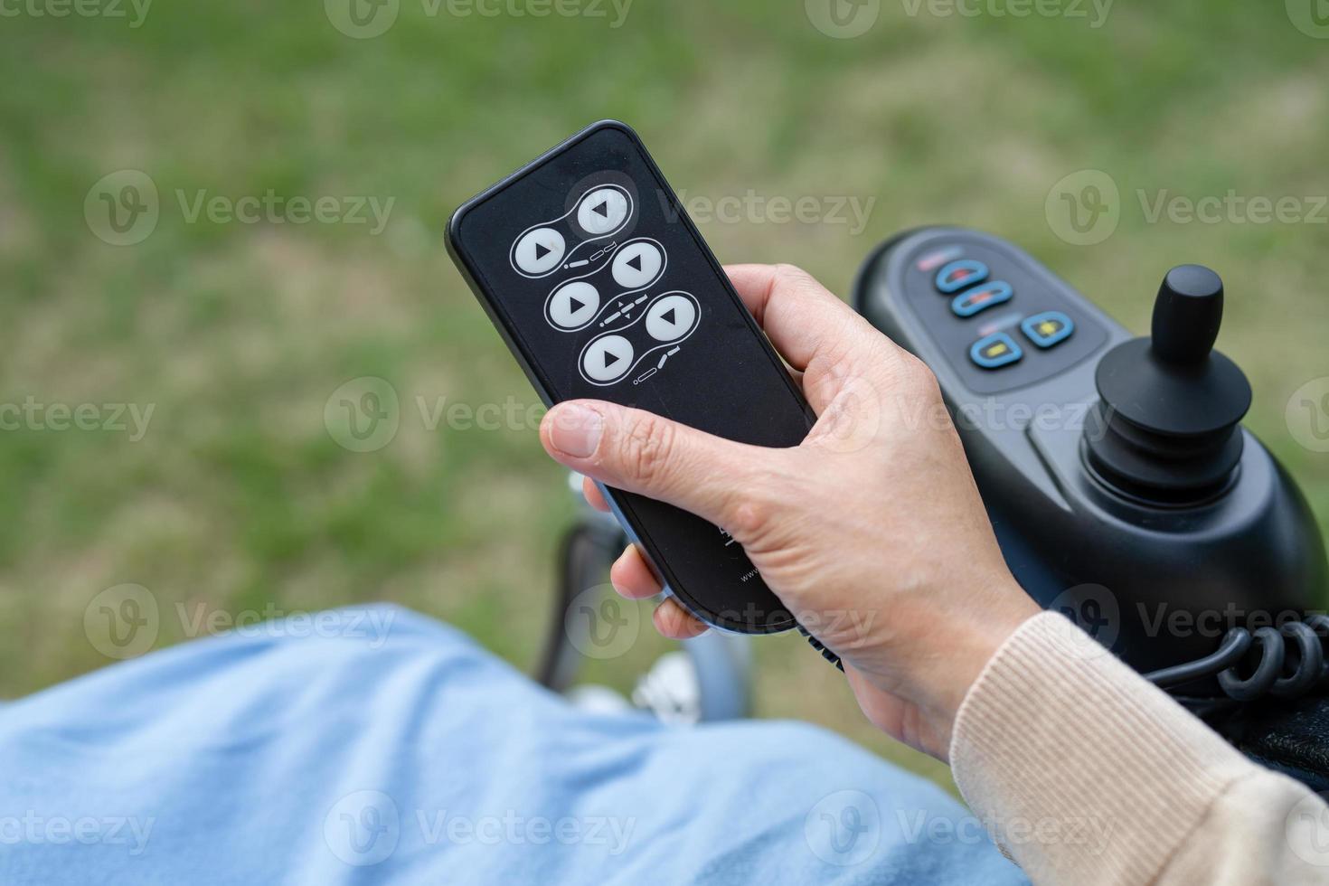 Asian woman patient on electric wheelchair with remote control at hospital. photo