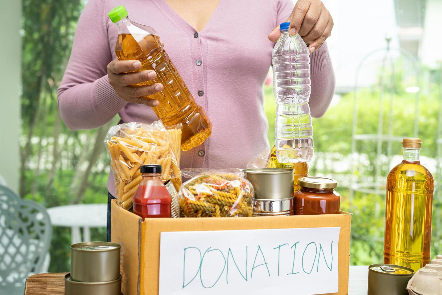 Volunteers putting various dry food in donation box for help people. photo