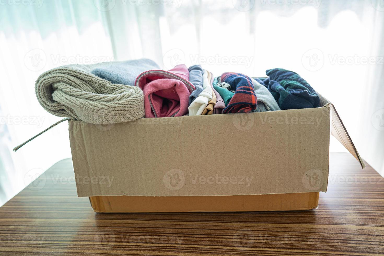 Donation box with used clothes at home to support help for poor people in the world. photo