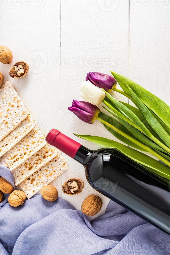 vertical festive background for the Jewish Passover holiday with traditional treats and tulips. white background. Flat layout. photo