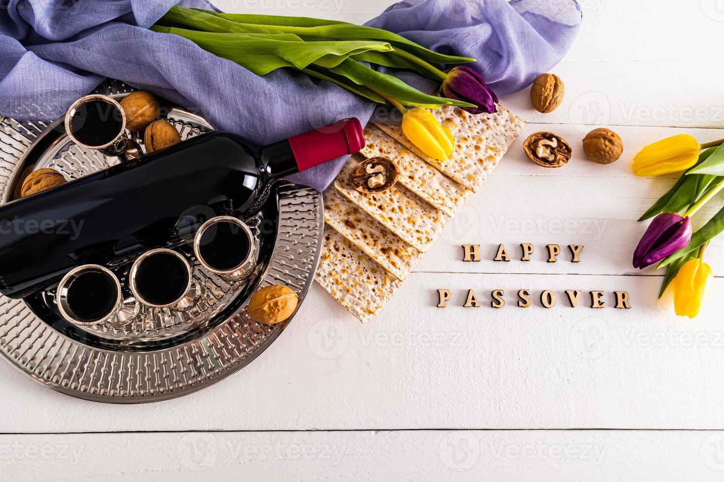 round silver tray with glasses of red wine, matzah, walnuts, a bottle of wine. flat layout. the concept of the Jewish Passover holiday. photo