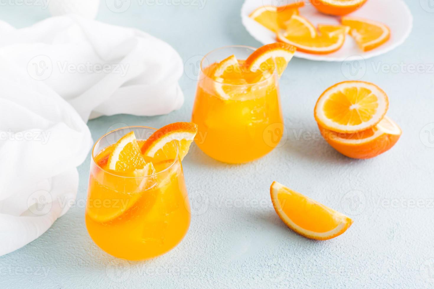 Hard seltzer cocktail with orange in glasses on the table. Homemade drink. photo