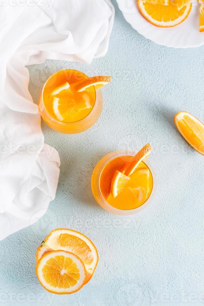 Hard seltzer refreshing orange cocktail in glasses on a table. Homemade drink. Top and vertical view photo