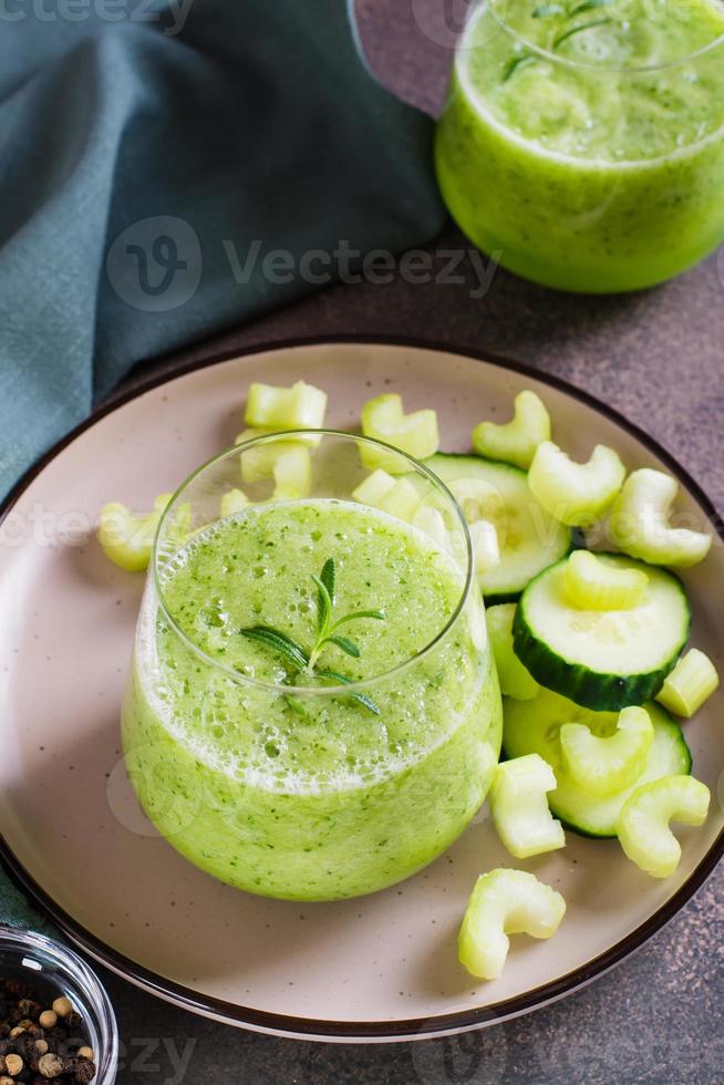 Cucumber and celery smoothie for vegetarian antioxidant diet in glass on table vertical view photo