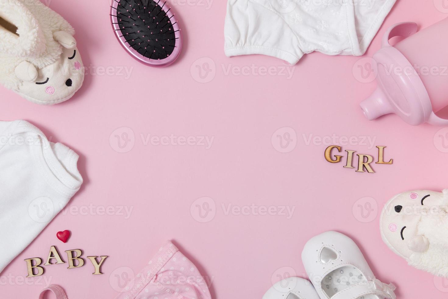 Top view composition with baby accessories and clothers on a colored pink background. Frame from baby accessories flat lay with copy space photo