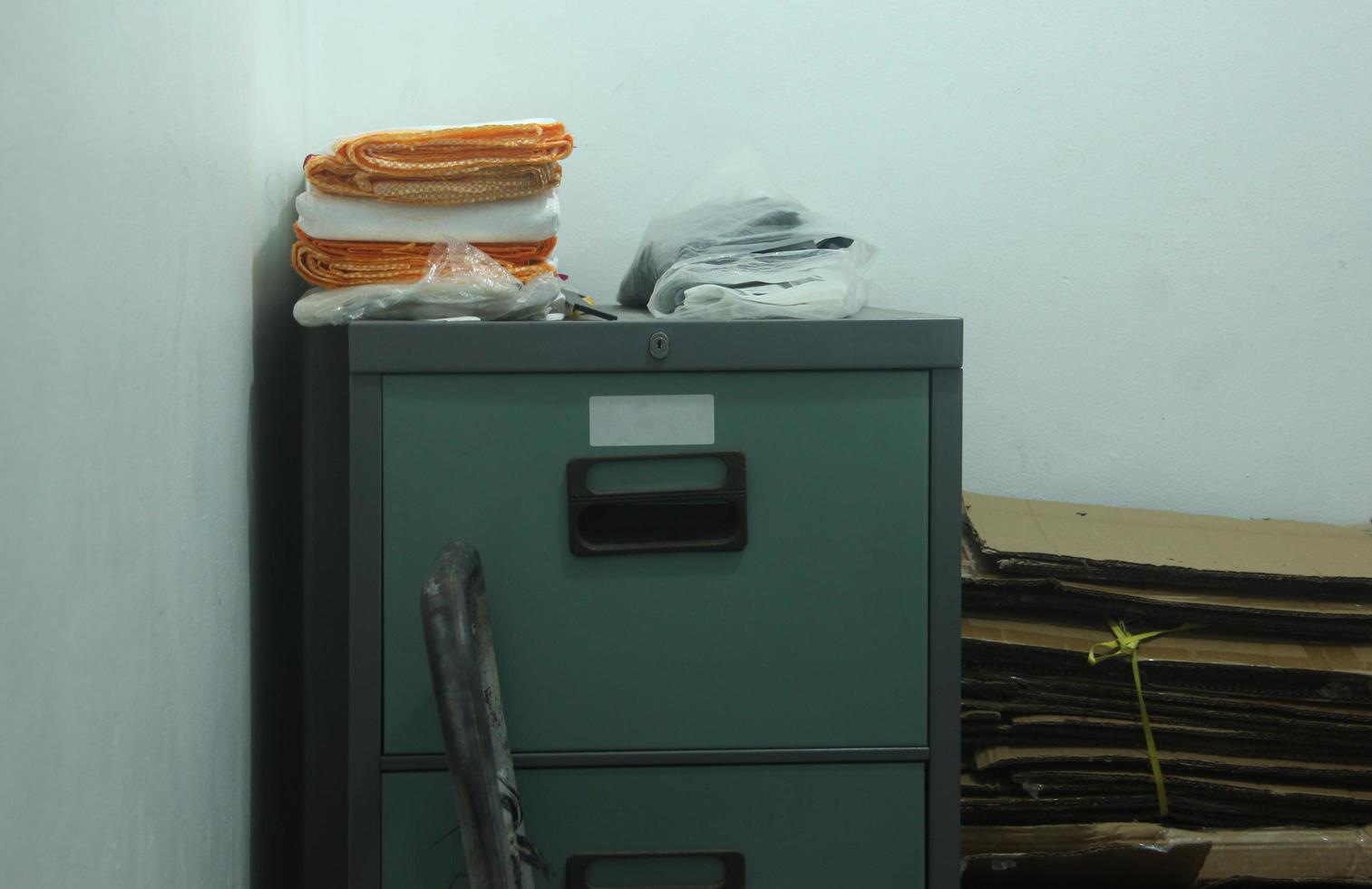 Old locker shelf to keep documents or other stuff, with tidy bag stack on top and cardboard stack beside it. Photo isolated on white walls indoor.