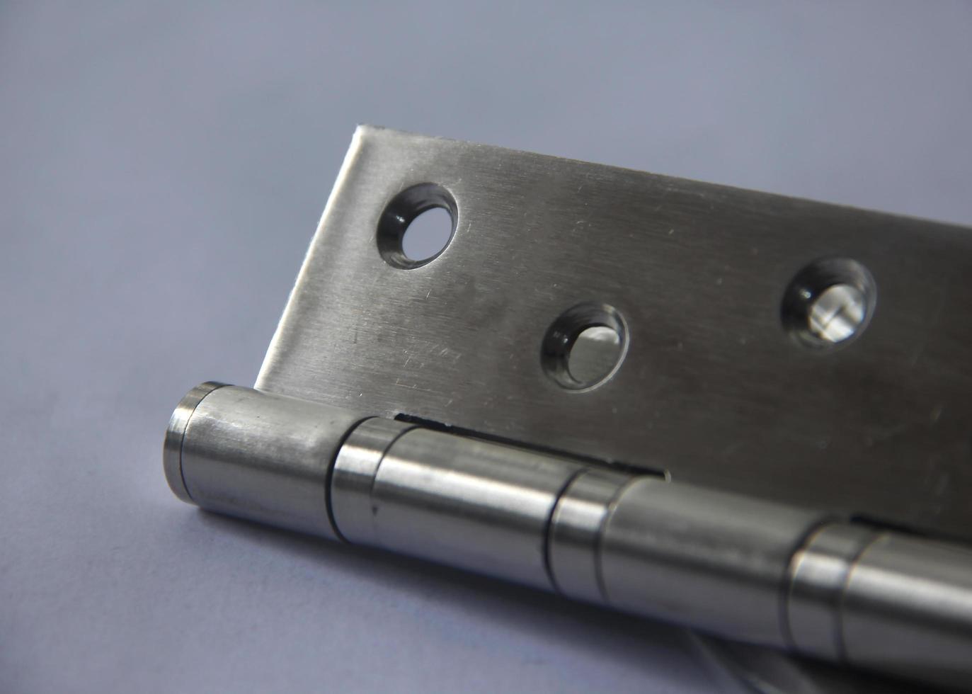 Butterfly door hinge with strong metal iron stainless steel material. Engsel kupu-kupu with four ball bearings. Industrial object equipment close up. photo