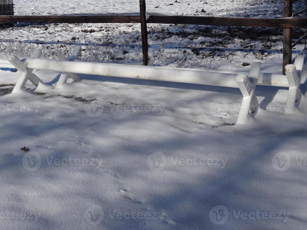 White obstacle bars - cavaletti covered with snow photo
