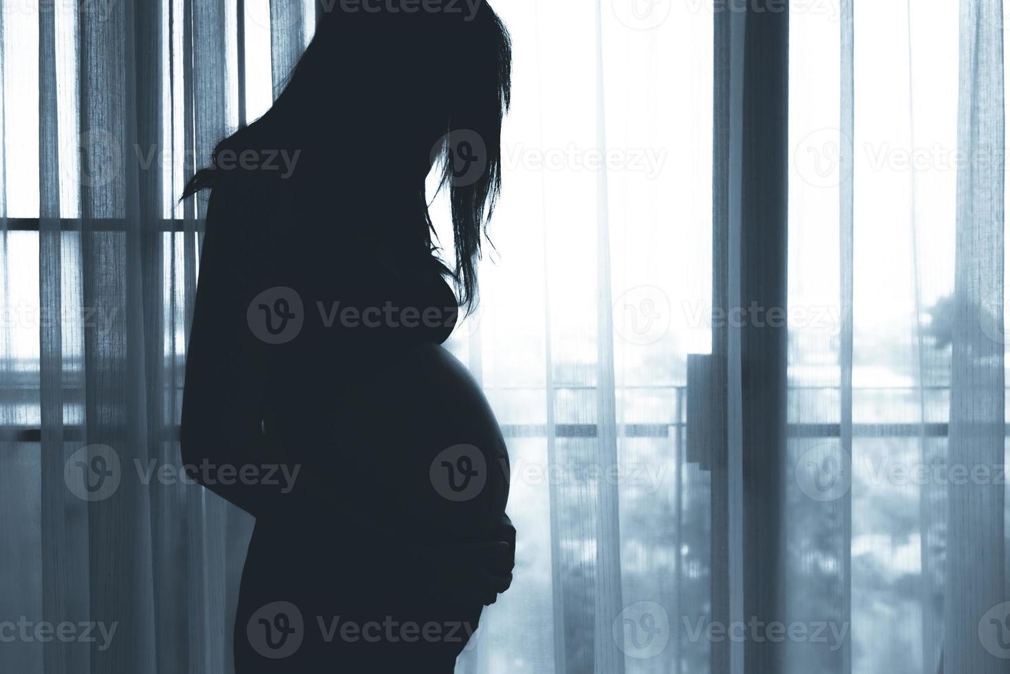 retrato de asiático embarazada mujer en el dormitorio foto