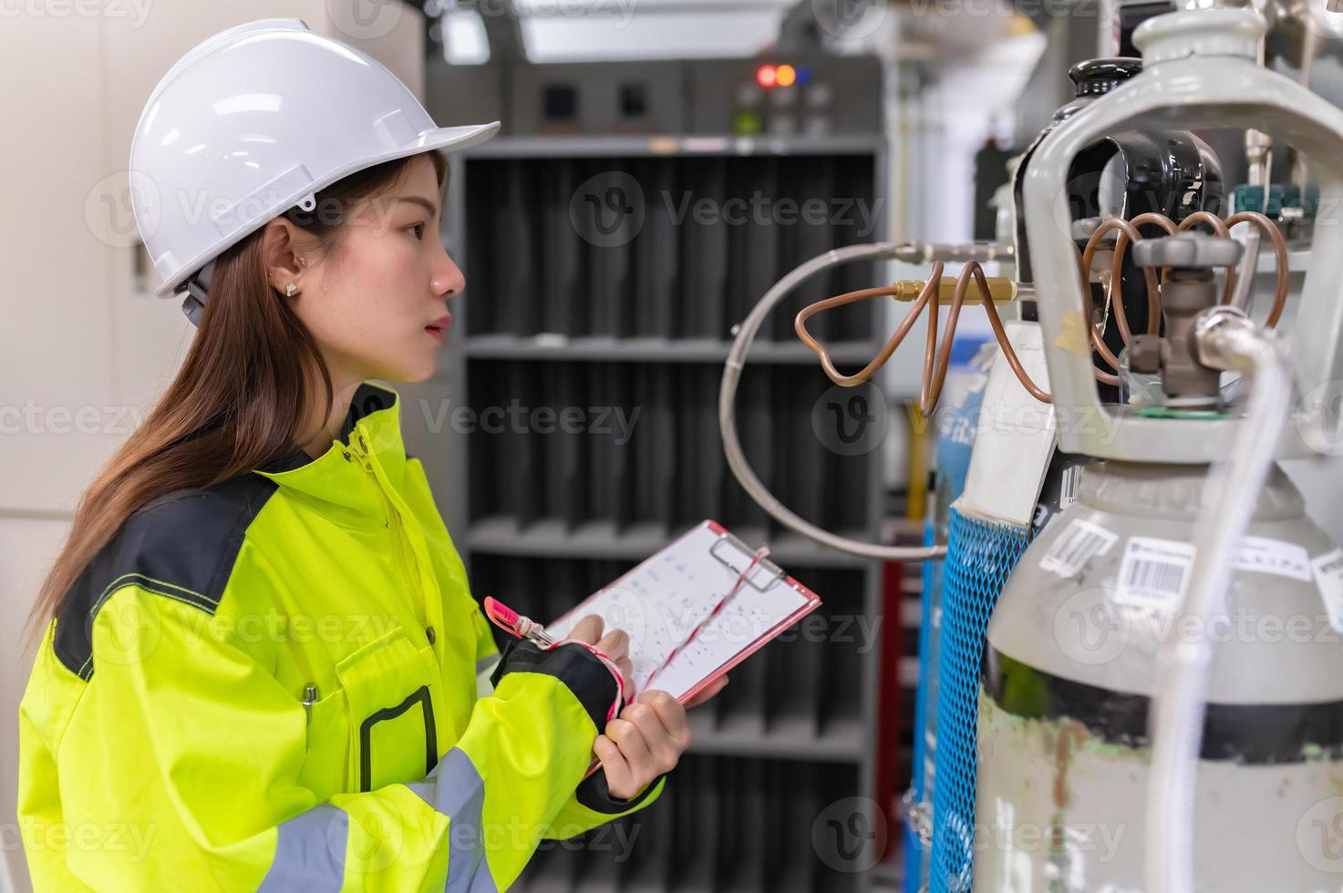 Asian engineer working at Operating hall,Thailand people wear helmet  work,He worked with diligence and patience,she checked the valve regulator at the hydrogen tank. photo