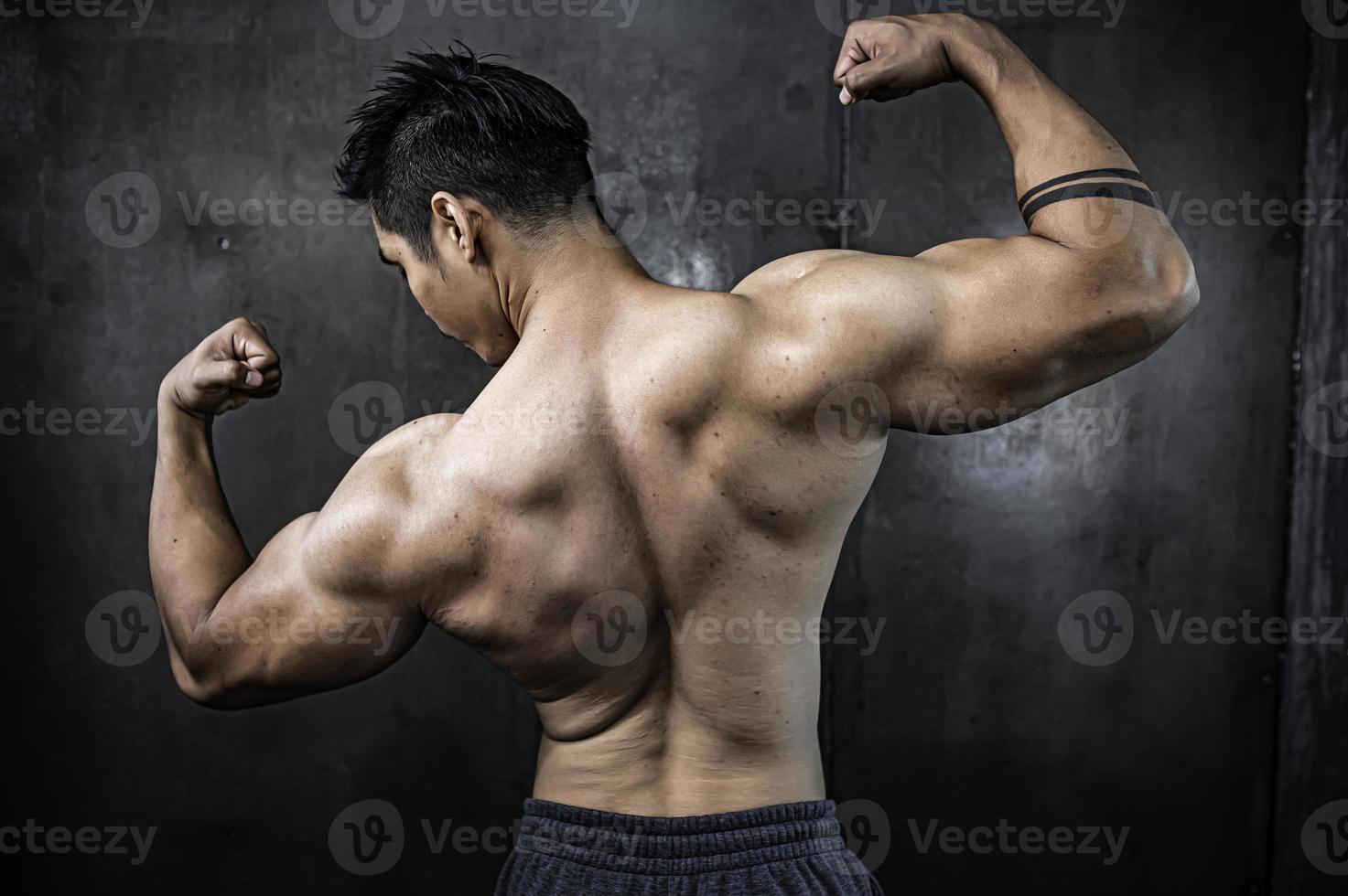 retrato de hombre asiático con gran músculo en el gimnasio, gente de tailandia, entrenamiento para una buena salud, entrenamiento de peso corporal, fitness en el concepto de gimnasio foto