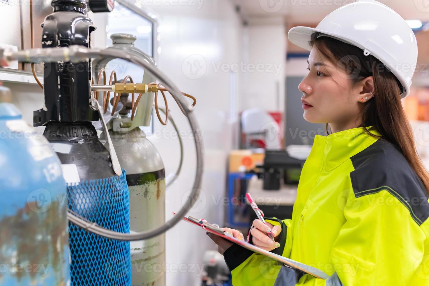 ingeniero asiático que trabaja en la sala de operaciones, la gente de tailandia usa casco, trabajó con diligencia y paciencia, revisó el regulador de la válvula en el tanque de hidrógeno. foto