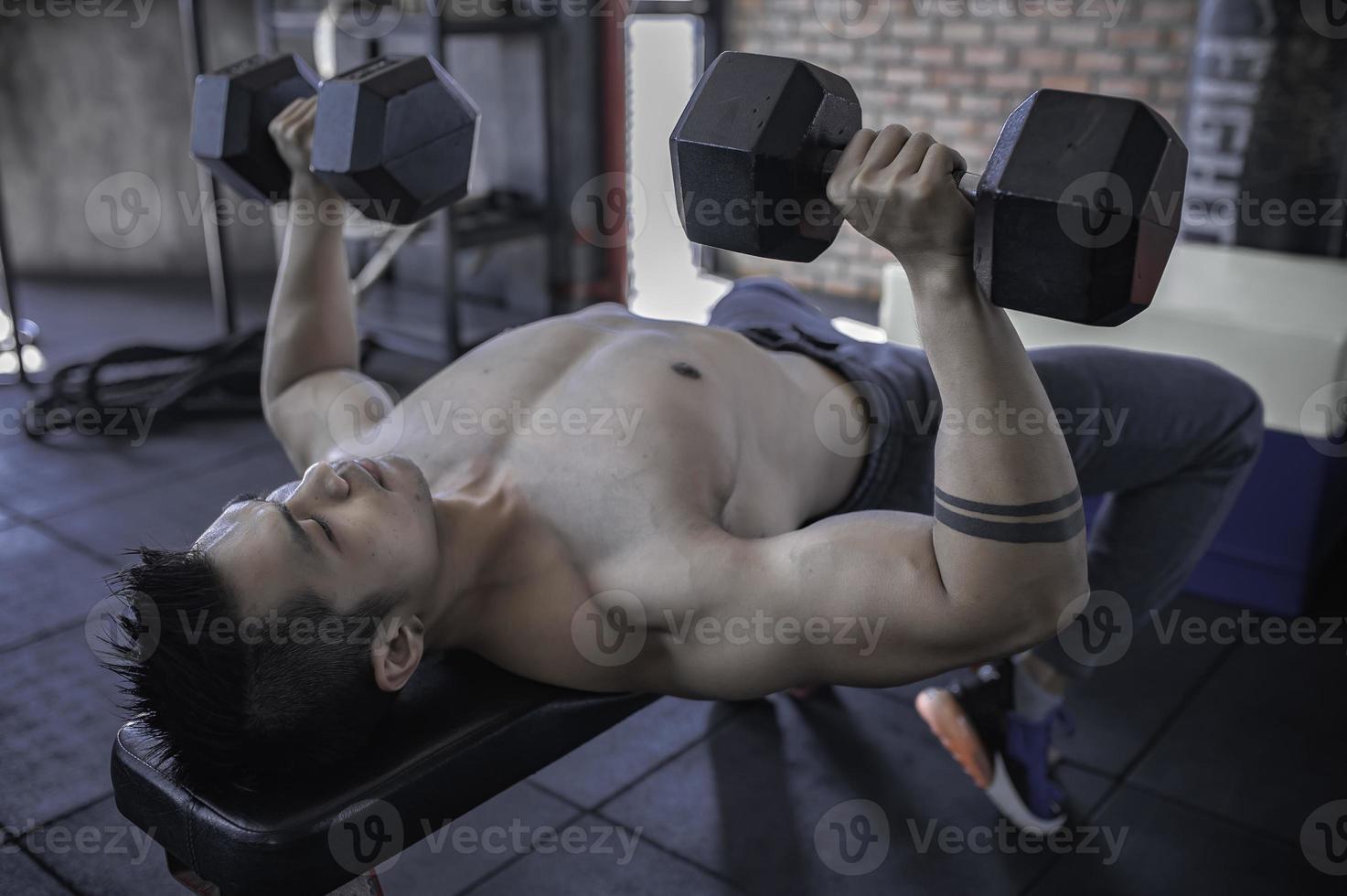 retrato de hombre asiático con gran músculo en el gimnasio, gente de tailandia, entrenamiento para una buena salud, entrenamiento de peso corporal, fitness en el concepto de gimnasio foto