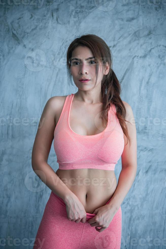 primer plano asiático hermosa chica deportiva en la pared del gimnasio, tailandia amor salud, concepto de entrenamiento de mujer delgada foto