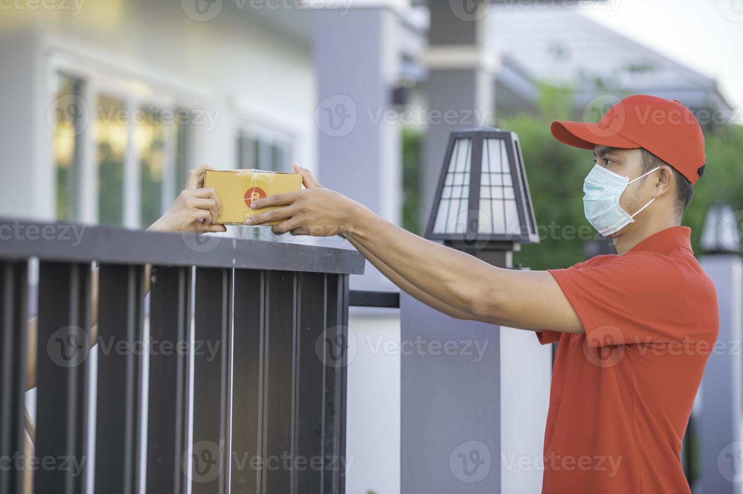 Asian Delivery  man wear protective mask in red uniform,Online food and product delivery concept,New normal in covid-19 photo