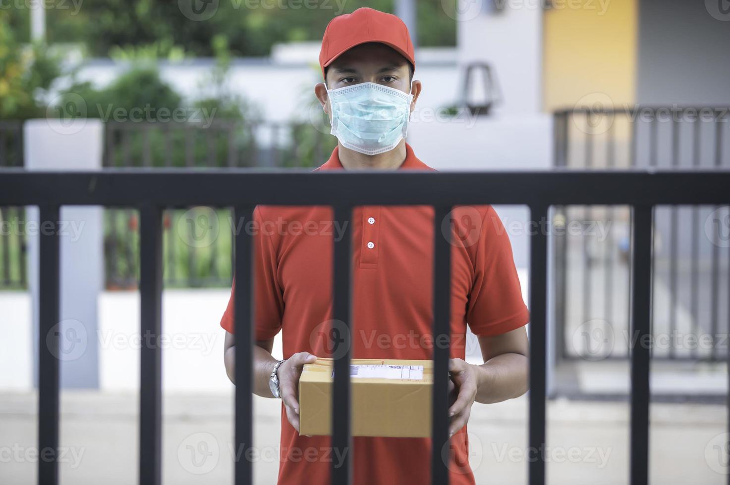 Asian Delivery  man wear protective mask in red uniform,Online food and product delivery concept,New normal in covid-19 photo