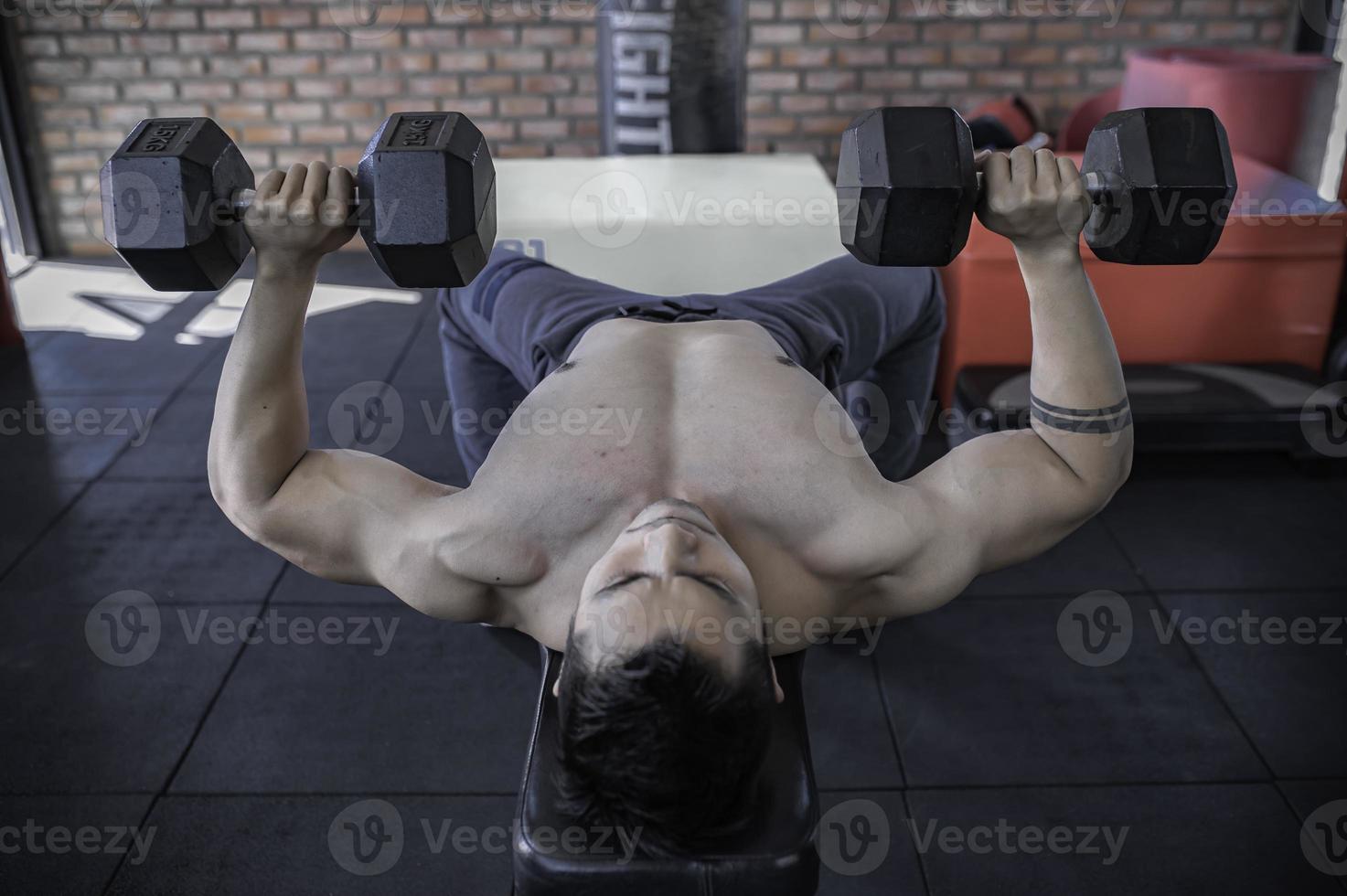 retrato de hombre asiático con gran músculo en el gimnasio, gente de tailandia, entrenamiento para una buena salud, entrenamiento de peso corporal, fitness en el concepto de gimnasio foto