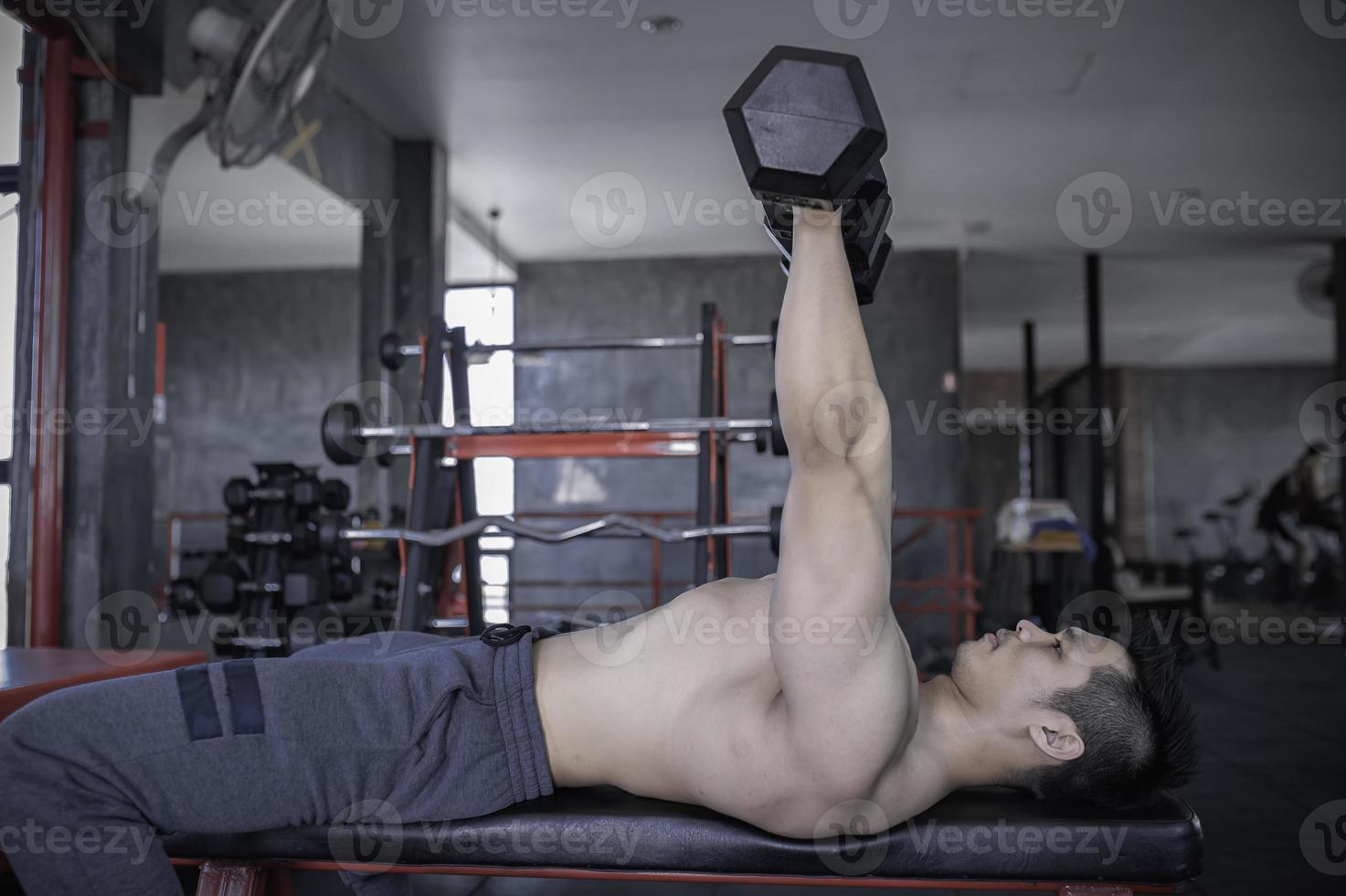 retrato de hombre asiático con gran músculo en el gimnasio, gente de tailandia, entrenamiento para una buena salud, entrenamiento de peso corporal, fitness en el concepto de gimnasio foto