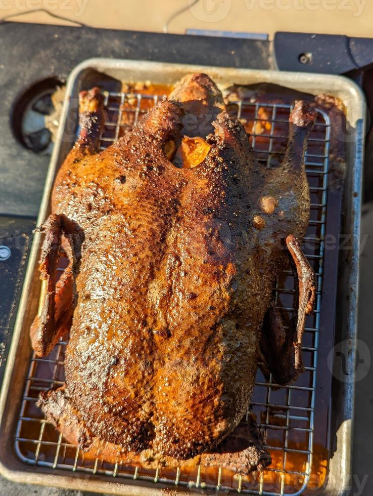 smoked duck on a tray ready to eat stuffed with oranges photo