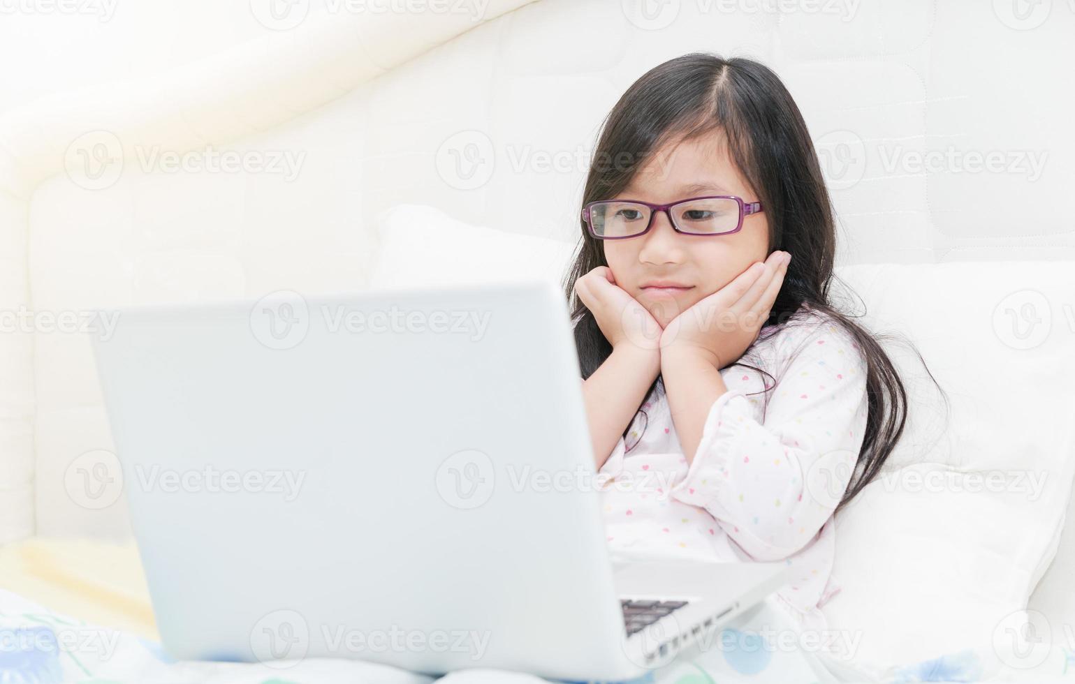 linda niña trabajando en ordenador portátil computadora concepto para educación foto