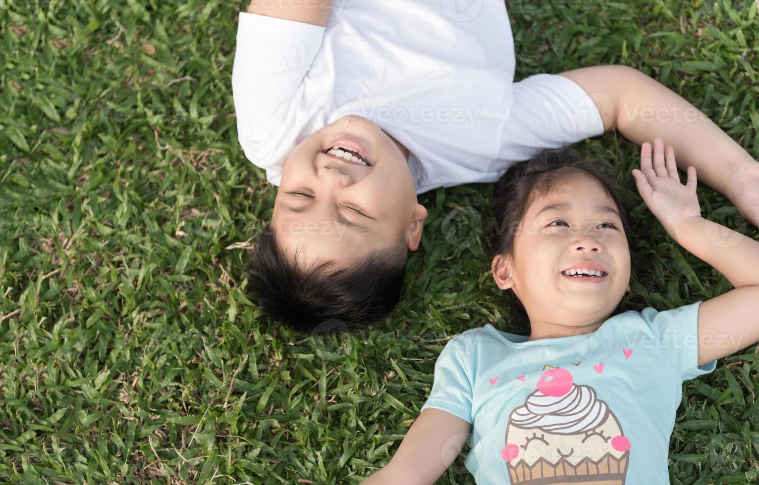 sonrisa niños mentira abajo en césped foto